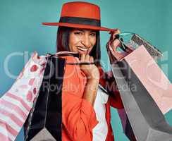 Fun, excited and trendy woman with shopping bags after retail therapy, spending and buying clothes. Portrait of stylish, edgy and funky model holding gifts and wearing colorful, fashionable red suit