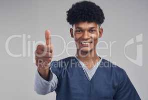 Im giving you the go ahead. a male nurse showing thumbs up while standing against a grey background.