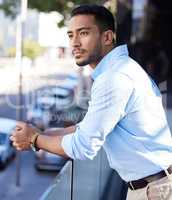 I always wonder if Im making the right decisions... a young businessman looking thoughtful while standing on the balcony outside an office.