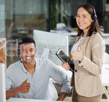 Our call success rate speaks for itself. a young man and woman showing thumbs up while using a computer while working in a call centre.