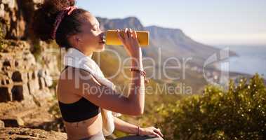 That climb made me thirsty. a young woman drinking water while out in mountains.