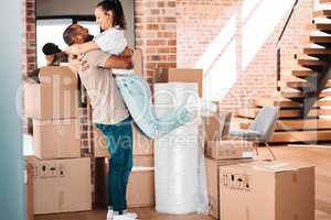 I want our first day here to be special. a couple looking cheerful while moving into their new home.