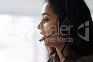One of our agents will be with you shortly... a young businesswoman wearing a headset while working in a call centre.