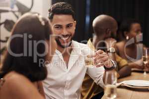 We never run out of things to say. a handsome young man sitting and enjoying a New Years dinner party with friends.