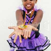 Look at my pretty pendant. a little girl holding a jack o lantern pendant in her hands against a white background.