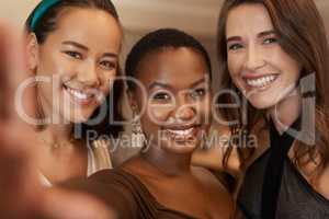 Got to get a selfie for social media. a young group of friends standing together and posing for a selfie during a New Years dinner party.