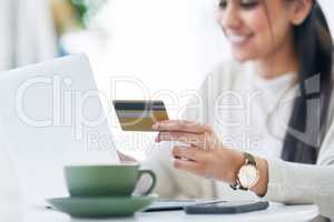 Getting her accounts all in order. a young businesswoman using a laptop and credit card in an office.