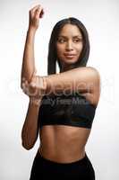 Stretching promotes muscle flexibility. Studio shot of a sporty young woman stretching her arms against a white background.