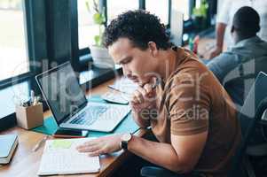 The key to doing well is always taking notes. a young businessman working in an office.