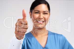 Im a force of God. Portrait of a young doctor showing a thumbs up sign against a white background.
