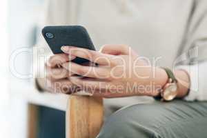 Improving workflow through mobile technology. Closeup shot of an unrecognisable businesswoman using a cellphone in an office.