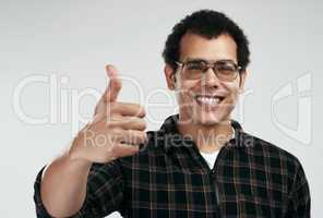 Im onboard. a handsome young man showing thumbs up while standing against a grey background.