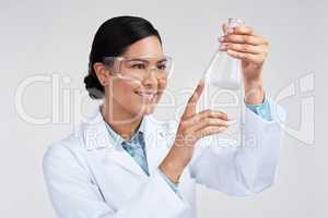 This is the reaction Im looking for. an attractive young female scientist examining a beaker filled with liquid in studio against a grey background.