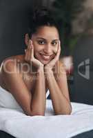 I totally love this place of bliss. Portrait of a young woman relaxing on a massage bed at a spa.