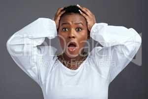 This is not good, not good at all. a woman looking worried while standing against a grey background.