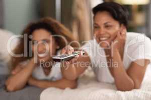 Binging babes. a young lesbian couple using a tablet while relaxing in their lounge at home.