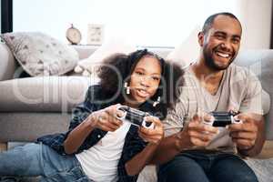 Youve met your match, dad. a young girl playing video games with her father at home.