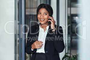 Hello, this is your future calling and its looking good. a young businesswoman using a smartphone in a modern office.