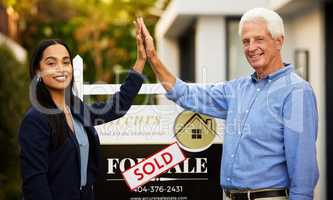 Another satisfied customer. Cropped portrait of an attractive young real estate agent and her male client high fiving next to a sold sign outside of his newly purchased home.