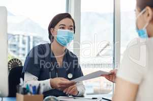 Here is a list of things you need to remember. a young female doctor giving a patient a document in an office.