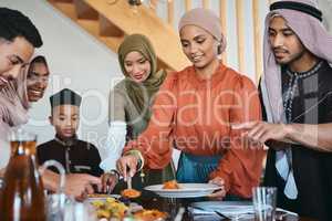 Fill up your plate. a muslim family dishing lunch for themselves.
