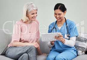 This is how easy it is for me to keep track of your health. a female nurse using a digital tablet while sitting with her patient.