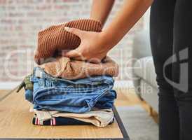 Keeping my closet clean and neat. a woman folding a load of laundry.