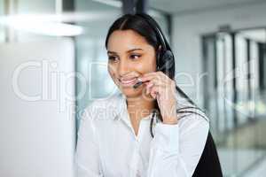 Hello, how can we help you today. an attractive young call centre agent sitting in the office and wearing a headset while using her computer.