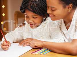 Mom makes doing homework fun. a young mother and daughter doing homework together at home.