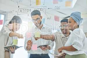 All roads lead to this specific point. a group of diverse young businesspeople working on a glass wipe board in the boardroom.