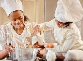 Baking together makes for good bonding. a mother and her daughter baking in the kitchen at home.