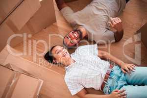 Weve been dreaming of owning our own home for so long. a happy couple lying on the floor together in their new home.