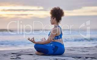Everyday is a great day for yoga. a young female doing yoga on the beach.