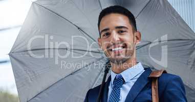 You cant rain on my parade. Cropped portrait of a handsome young businessman with an umbrella on his morning commute into work.