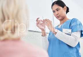 Making sure the dosage is just right. a female nurse getting ready to inject her patient.