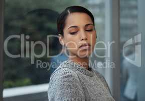 Dreaming about white beaches. a young businesswoman taking a break and leaning against a window.