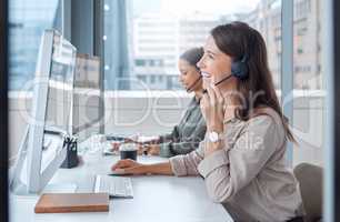 Hi there how may I help you. two young female call center workers in their office.