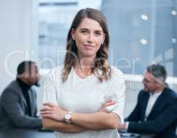 Believing in yourself can enhance your resilience. Portrait of a confident young businesswoman standing in an office with her colleagues in the background.