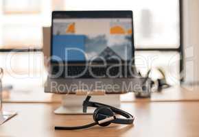 All set up and ready to help. Still life shot of a wireless headset on a desk in a call center.