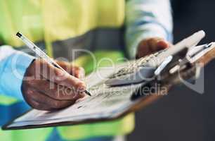 Our stock-take needs to be accurate. an unrecognizable contractor standing alone in the warehouse and writing on a document during stock-take.