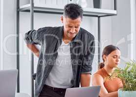 Good posture is important. a young businessman in pain in an office.