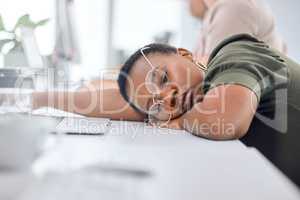 Chasing your dreams is hard work. a young businesswoman sleeping at her desk in an office.