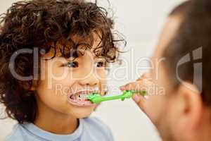 Be true to your teeth and they wont be false to you. a father teaching his son how to brush teeth at home.