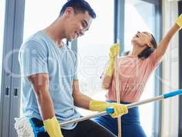 Remember to have fun. a couple taking a break from mopping their house to dance around.