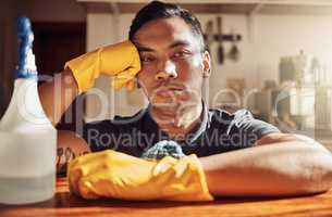 I should have called a cleaning service. Portrait of a young man looking unhappy after cleaning the kitchen at home.