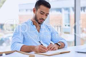 Always keep track of your ideas. a young businessman writing notes in his notebook.
