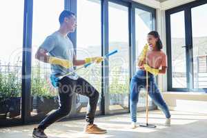 Feeling young at heart. a couple taking a break from mopping their house to dance around.