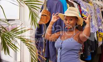 Were you taught not to stare I dont mind. Portrait of a young attractive woman wearing a sunhat while posing against clothes at home.