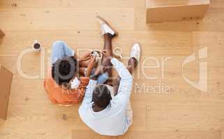 Opening up a new chapter of our lives. a young couple sitting on the floor while looking at an ultrasound picture at home.