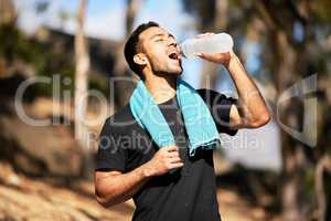 Exercising is the best part of my day. a man drinking water while out of a run.
